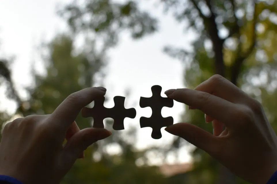 Hands connecting puzzle pieces representing integration of technology solutions at NNOCONN