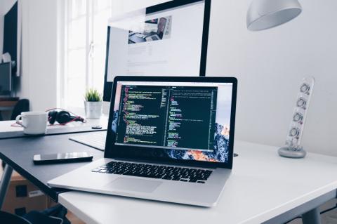 Modern workspace with multiple monitors, representing remote IT support and monitoring
